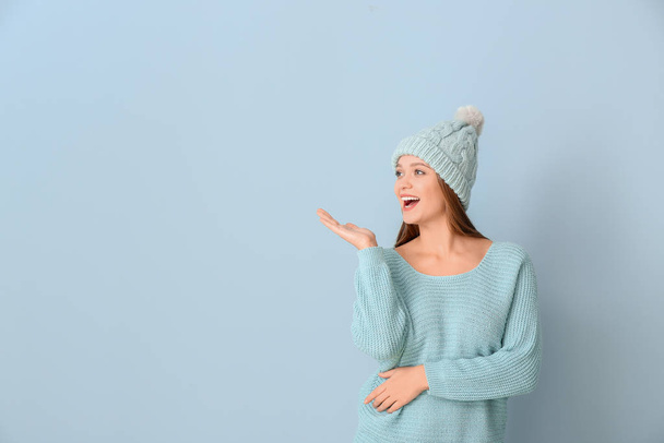 Krásná žena v zimě oblečení na barevném pozadí - Fotografie, Obrázek