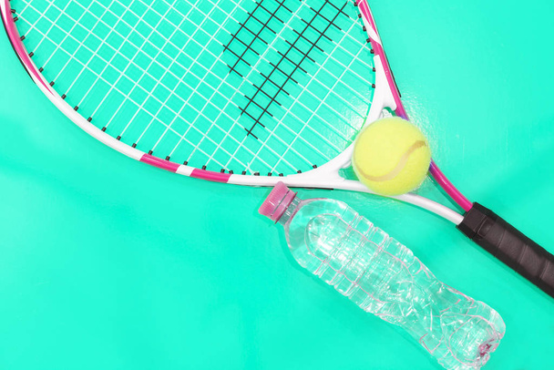Τένις σε φωτεινό φόντο. Μπουκάλι με νερό, ρακέτα, μπάλα. Φωτογραφία στο Studio - Φωτογραφία, εικόνα