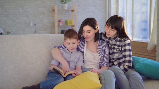 Duas jovens felizes e um menino lendo um livro
 - Filmagem, Vídeo