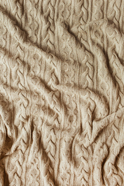 Бежеве в'язане плетене покривало з орнаментом. Затишний декор текстильної концепції
. - Фото, зображення