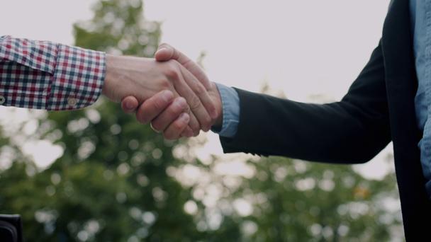 Gros plan des hommes bras des hommes d'affaires serrant la main à l'extérieur dans la rue
 - Séquence, vidéo