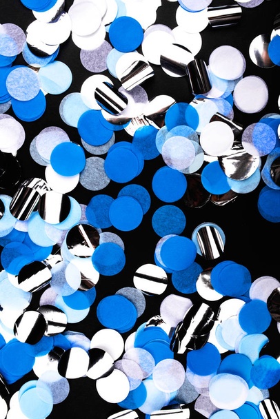 Silver, blue and white confetti on black background. - Photo, image
