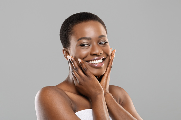 Attractive black girl touching her smooth skin on cheeks - Photo, Image