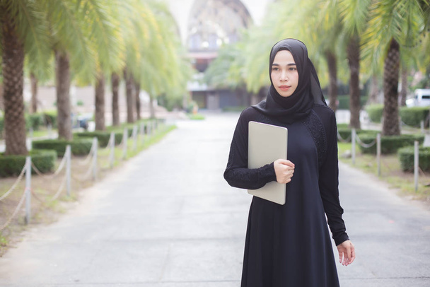 Portrét muslim žena v černé hidžáb s notebookem příroda pozadí. - Fotografie, Obrázek