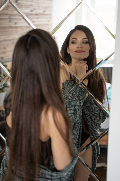 Girl looking at herself in large mirror - Фото, зображення