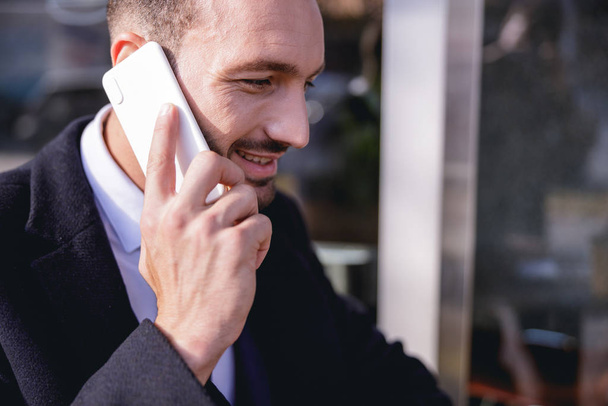 Positive delighted businessman holding telephone near ear - Fotoğraf, Görsel