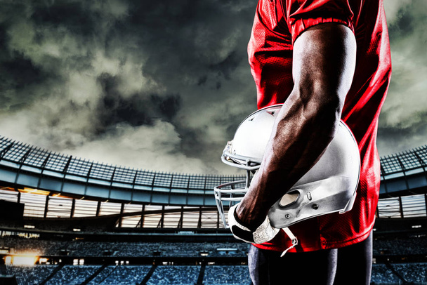 American football player against rugby stadium at dawn - Foto, imagen