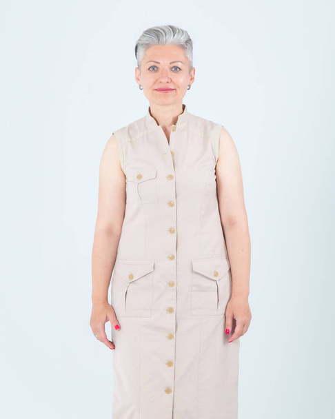 Middle-aged woman standing on a light background. - Foto, imagen