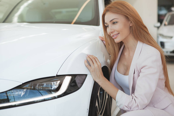 Gorgeous woman choosing a new car at the dealership - Фото, изображение