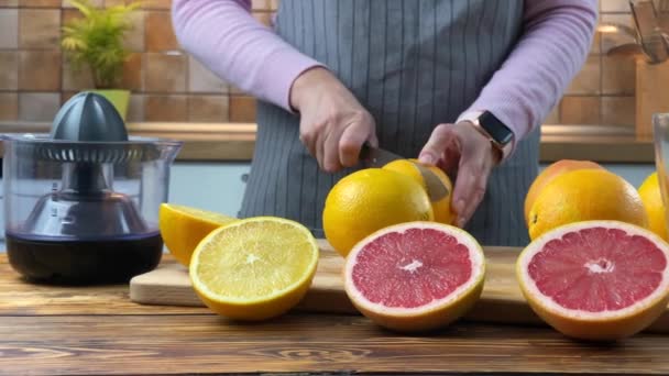 Mulher está cortando frutas cítricas na cozinha
 - Filmagem, Vídeo