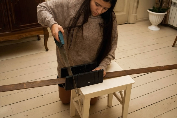 The girl saws a wooden jamb - Foto, Bild
