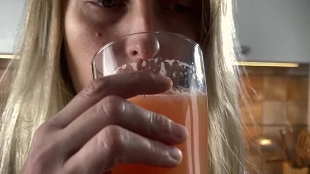 Kobieta pije świeży naturalny sok cytrusowy - Materiał filmowy, wideo