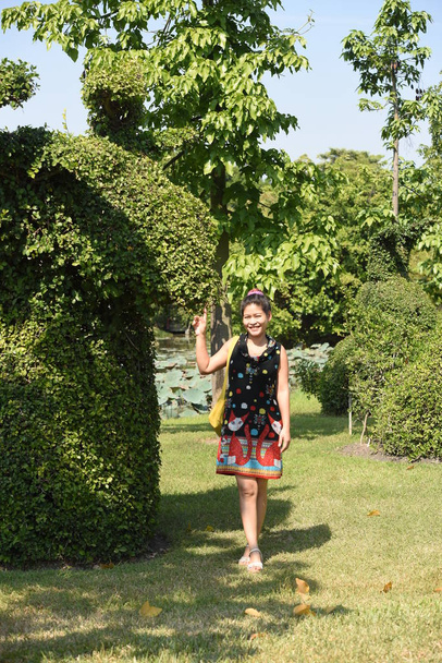 молодая азиатка позирует в цветочном парке с красочными цветами днем
   - Фото, изображение