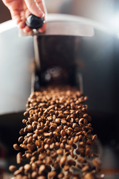 The flow of coffee beans from hand open flap of the cooling mixe - Foto, Imagen