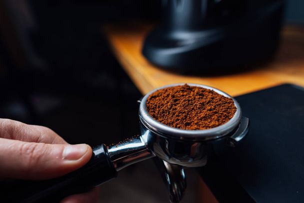portafilter full of ground coffee in a hand - Foto, Imagen