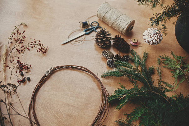 Fazendo ramos wreath.Fir Natal, cones de pinho, linha, scisso
 - Foto, Imagem