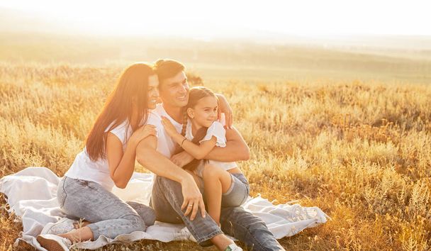 Happy family hugging and resting in nature - Photo, image