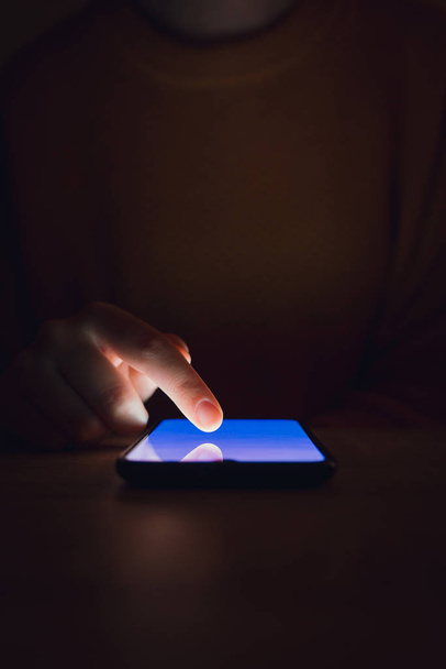 Στοκ φωτογραφία μιας γυναίκας που χρησιμοποιεί το smartphone στο σκοτάδι - Φωτογραφία, εικόνα