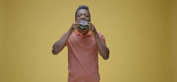 Nuori mies syö kaksi voileipää
 - Valokuva, kuva
