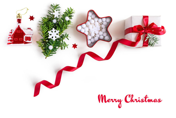 Frame made of christmas gifts with red ribbons, pine branches, toys on white background - Fotó, kép