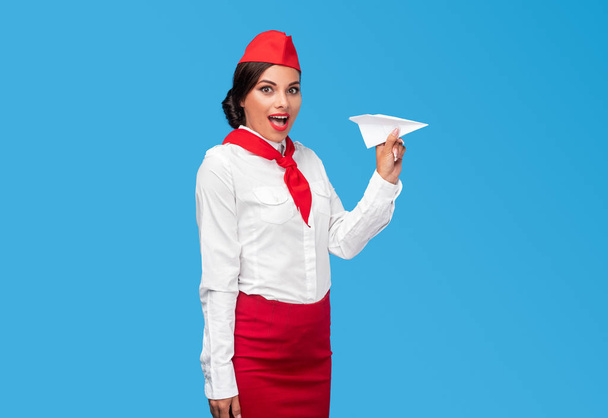 Amazed flight attendant near paper airplane - Foto, Imagen