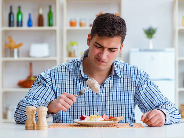 Man eating tasteless food at home for lunch - Photo, image