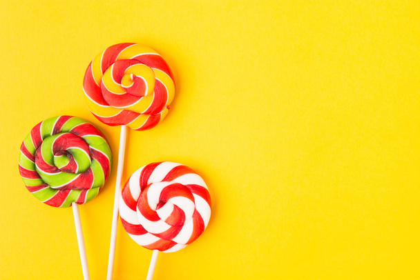Three colorful Christmas candies on stick. Sweet food for birthday. Lollypop. Copy space. Flat lay - Фото, изображение