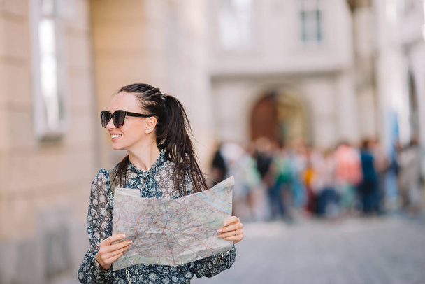 Mujer joven con un mapa de la ciudad. Viajar chica turística con mapa en Viena al aire libre durante las vacaciones en Europa
. - Foto, Imagen