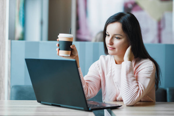Freelancer girl at a laptop with coffee thinks - Фото, зображення