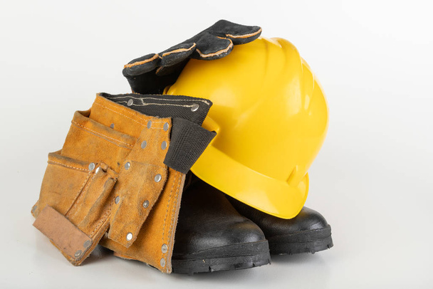 Helmet, work boots and gloves on a white table.  - Φωτογραφία, εικόνα