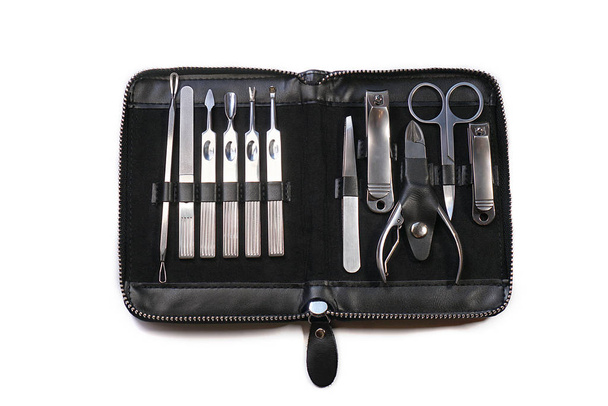 Metallic manicure set with black case on an isolated white background. Beauty salon and tools for nails. Women's handbag gift - Foto, Imagen