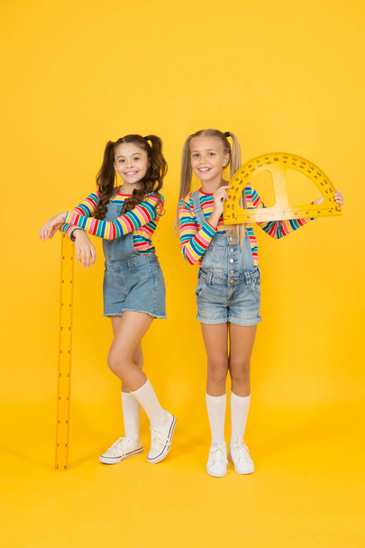 Interesting task. School club. School children with measuring instruments. Little girls ready geometry lesson. Cute schoolgirls holding protractor and ruler for school lesson. Studying measurement - Foto, Bild