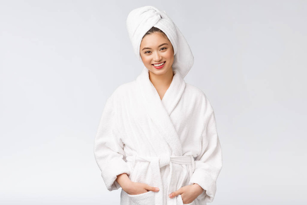 Nuoren onnellisen aasialaisen naisen muotokuva kylpytakissa. Eristetty valkoisella taustalla
. - Valokuva, kuva