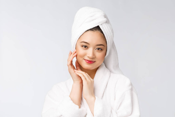 Nuoren onnellisen aasialaisen naisen muotokuva kylpytakissa. Eristetty valkoisella taustalla
. - Valokuva, kuva