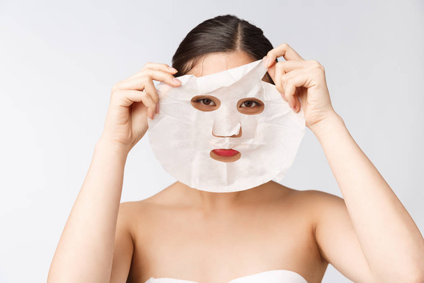 Spa, opieka zdrowotna. Kobieta z maską oczyszczającą na twarzy odizolowana na białym tle. - Zdjęcie, obraz