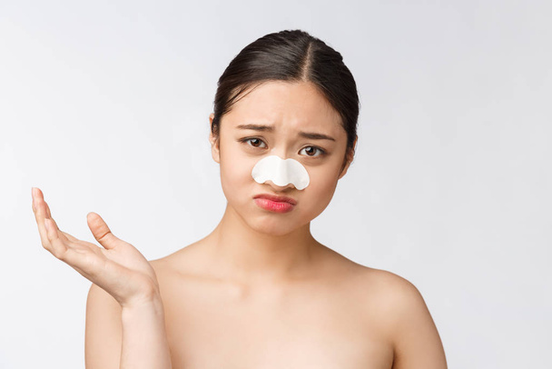 Cosmetologie. Portret van mooi vrouwelijk Aziatisch model met masker op neus. Close-up van gezonde jonge vrouw met een zuivere zachte huid en frisse natuurlijke make-up. - Foto, afbeelding