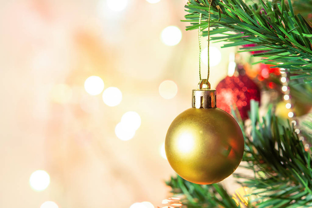 Decoración de Navidad. Colgando bolas de oro en las ramas de pino cristo
 - Foto, imagen