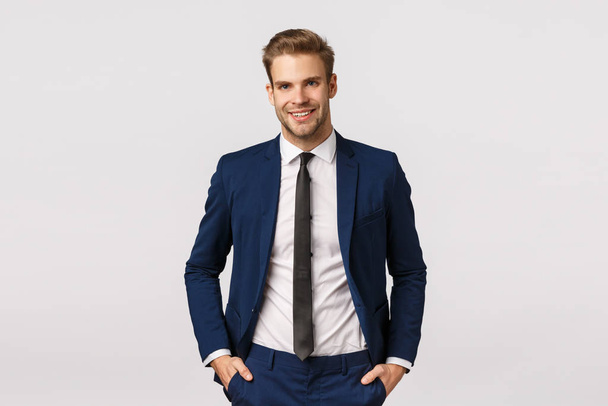 Handsome confident blond bearded businessman, holding hands in pockets, smiling joyfully, give professional vibe, discussing business, double his income, become successful, white background - Photo, Image