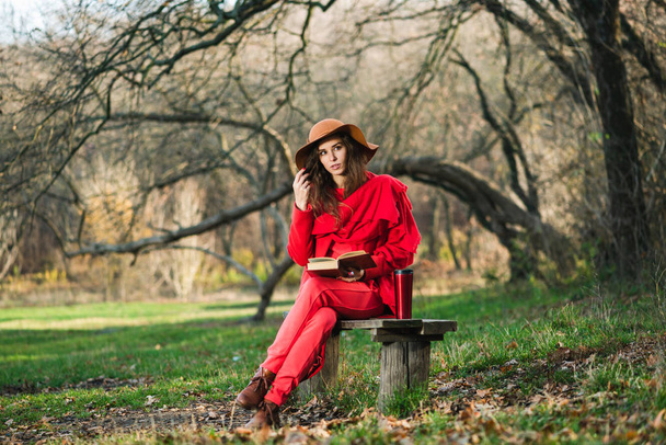 Stylish brunette read book on park bench - Photo, Image