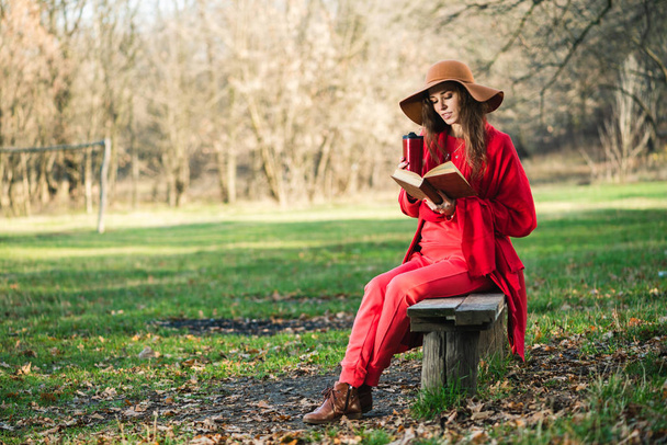 Mujer leer libro en el parque con termo
 - Foto, Imagen