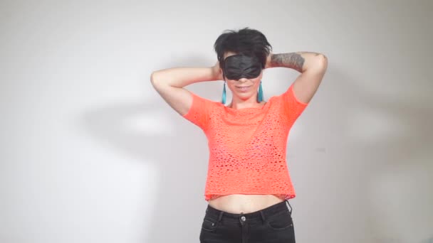 девушка перед маской для сна, в оранжевой футболке с татуировкой на руке
 - Кадры, видео