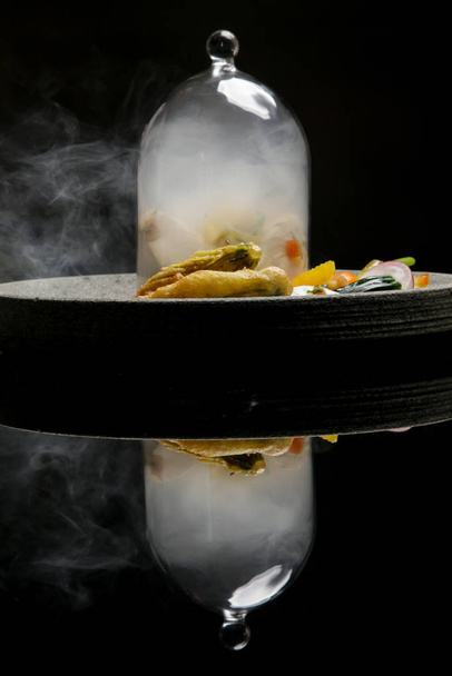 Minute smoked butterfish escalope served with steamed vegetable.  Exquisite dish. Creative restaurant meal on black with reflection - Photo, Image
