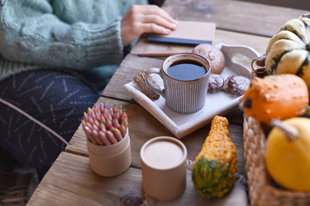 Autumn, pumpkins, hot steaming cup of coffee on a wooden table background. Seasonal, morning coffee, sunday relaxing and still life concept. Plans for the day. - Фото, изображение