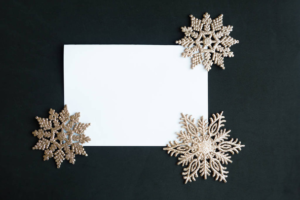 White mockup blank and golden Christmas decorations on black background. Beautiful Xmas greeting card. Copy space for the text - Photo, Image
