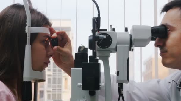 Офтальмологическое лечение - молодая женщина проверяет остроту зрения с помощью аппарата - реакция зрачка на свет бросает объектив - яркий шкаф
 - Кадры, видео