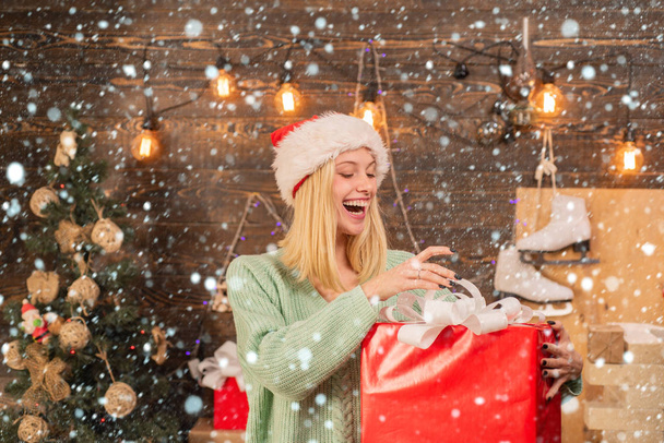 Christmas decorations and gift box on wooden background. True Emotions. Young woman with christmas present boxes in front of christmas tree. - Фото, зображення