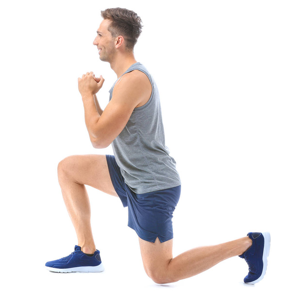 Sporty young man training against white background - Foto, Imagen