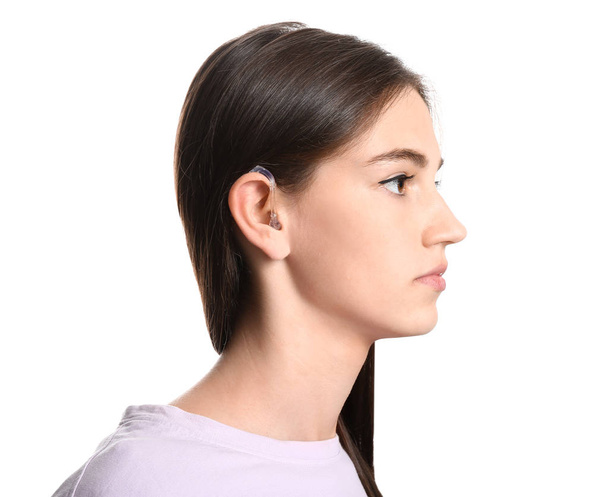 Young woman with hearing aid on white background - Foto, Bild
