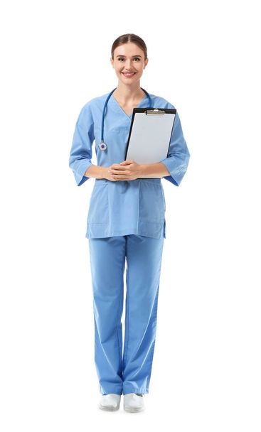 Portrait of female doctor with clipboard on white background - 写真・画像