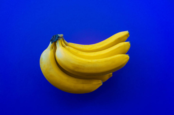 Trendy blue concept. Bunch of yellow bananas Color of the year 2020. - Φωτογραφία, εικόνα